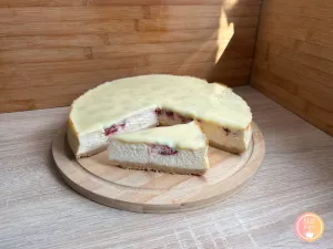 Kremowy sernik z malinami i polewą z białej czekolady